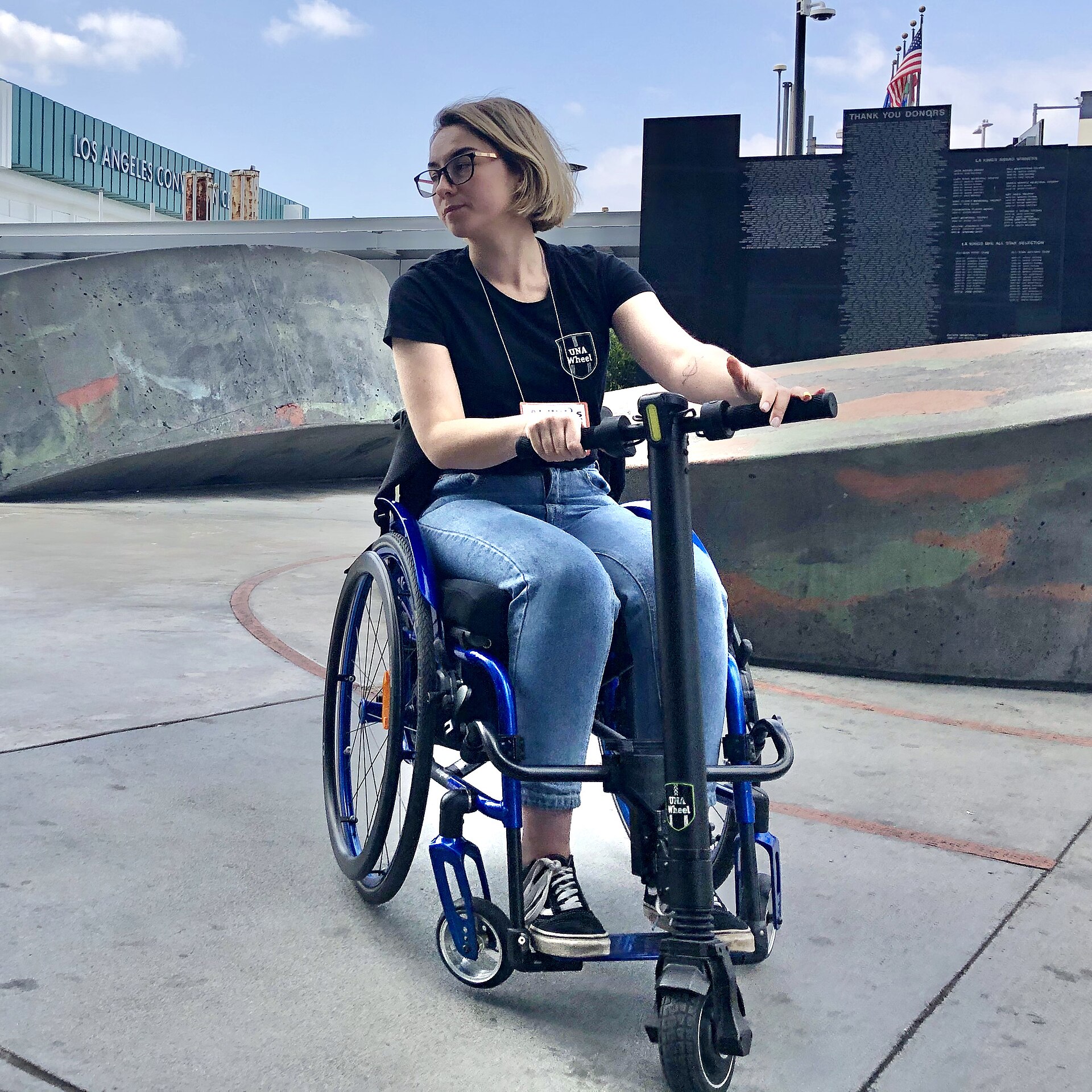Motorized wheelchair with electric power assist attachment