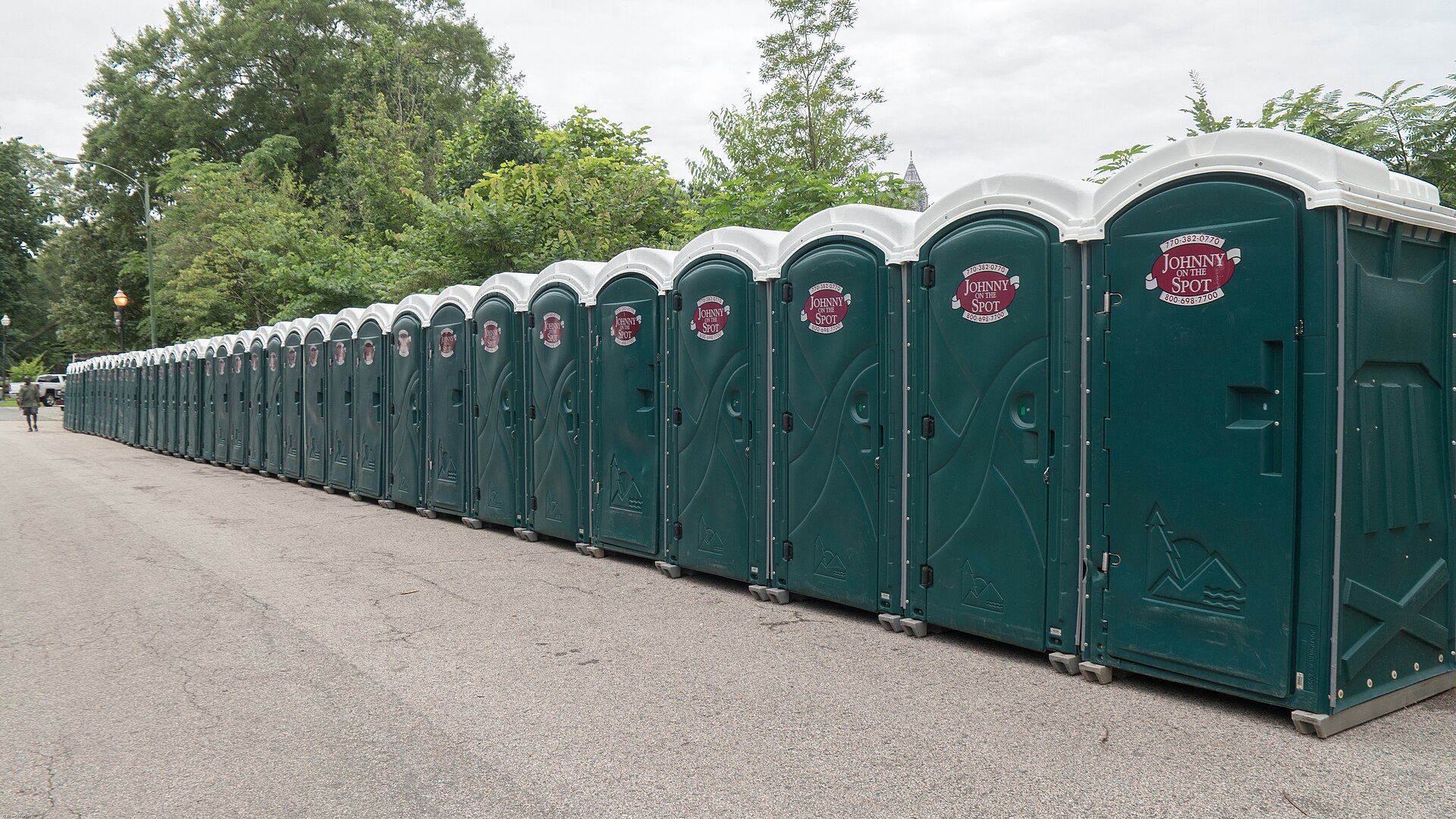 Row of portable sanitation toilets lined up for an outdoor event